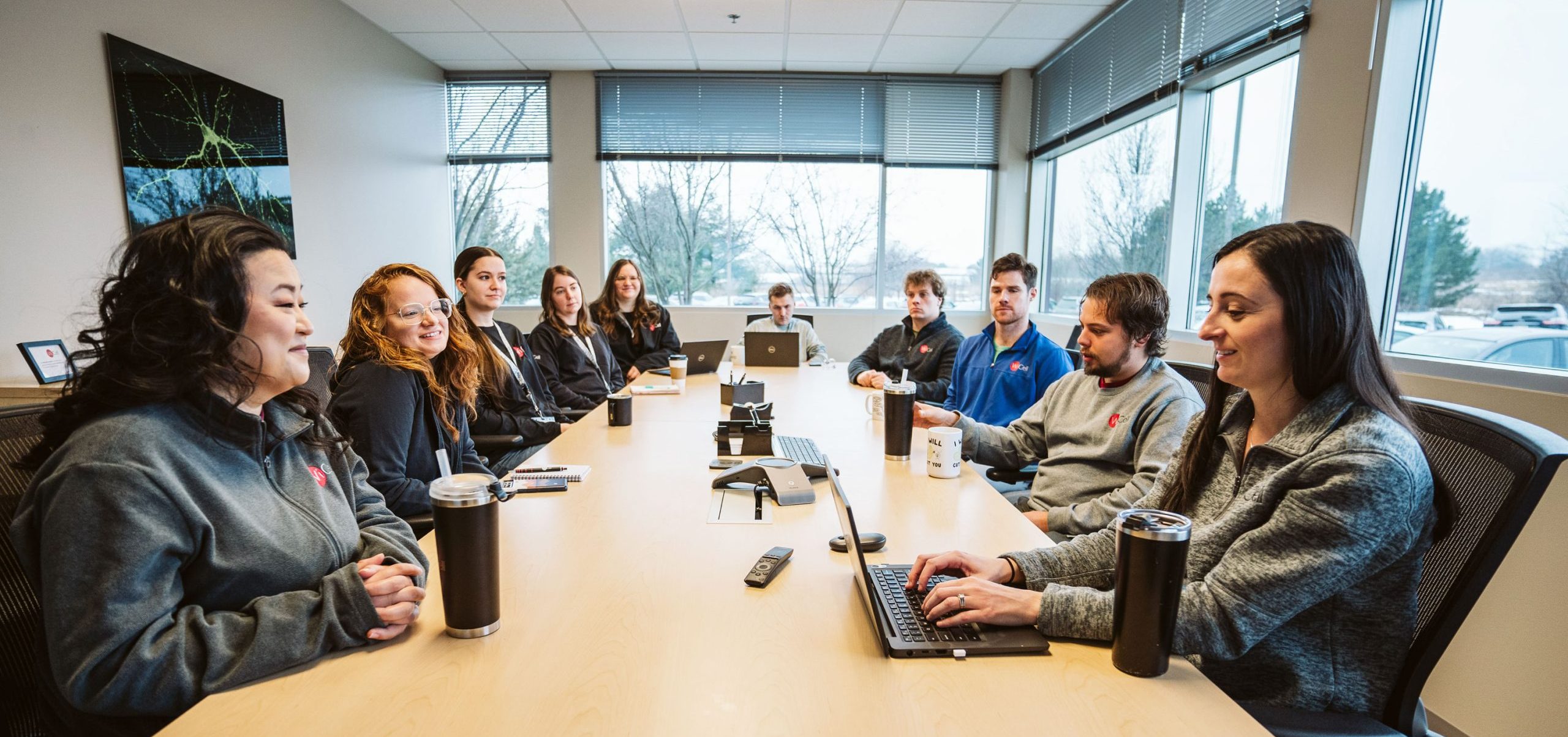 A team of scientists sitting at a conference room table for a meeting.