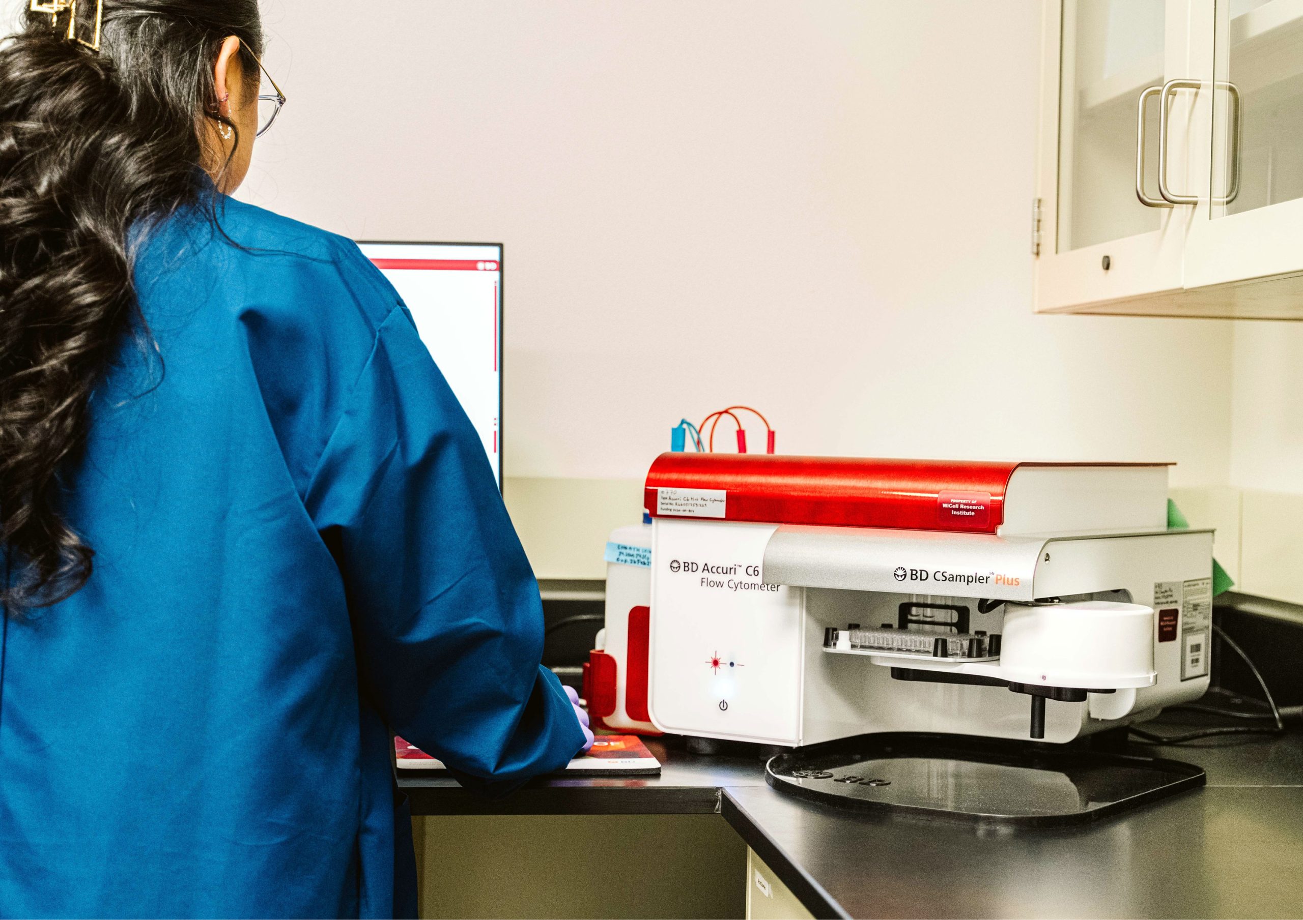 A scientist conducts an experiment using the BD CSampler Plus machine.