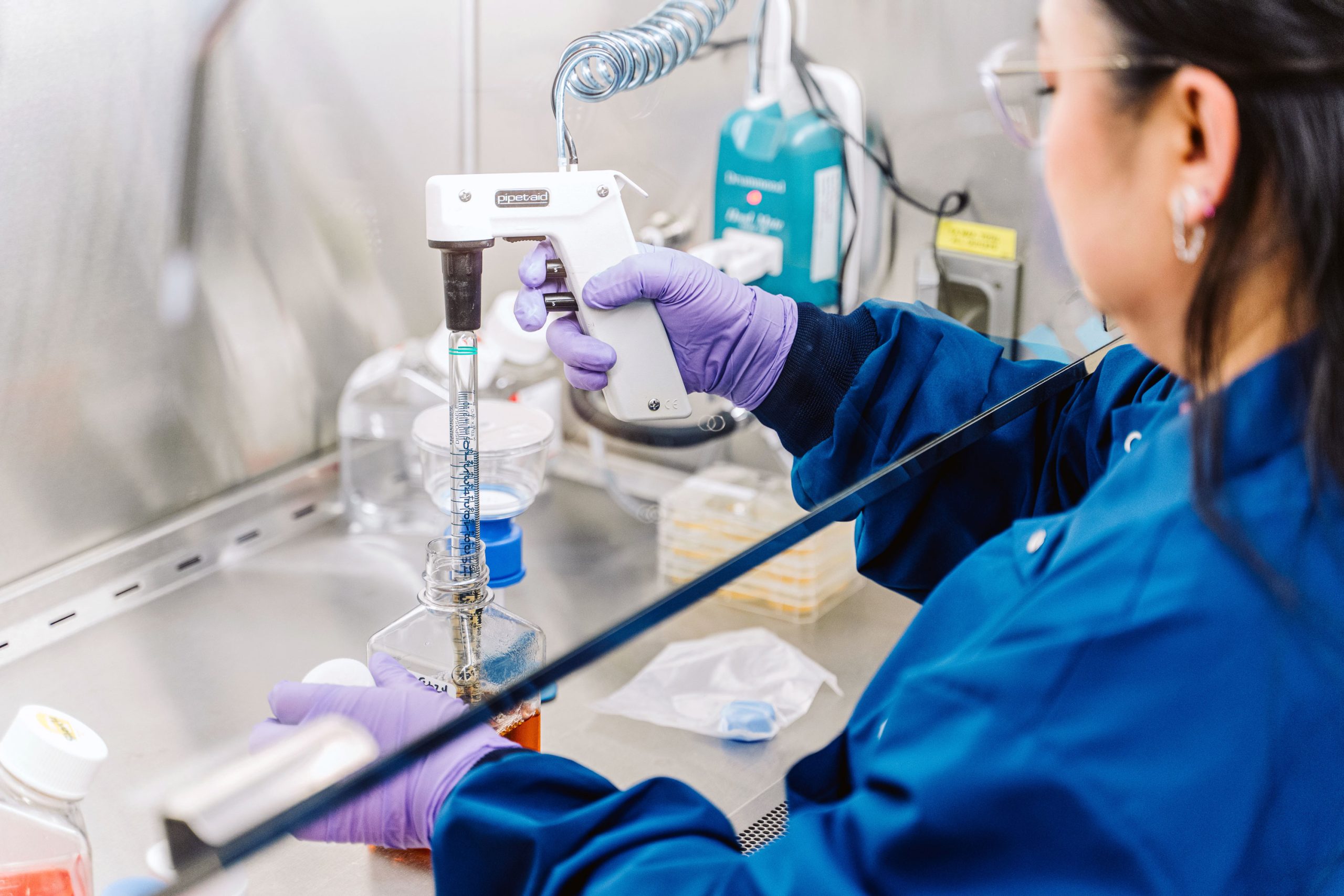 A scientists conducts an experiment on human embryonic stem cells in a fume hood.